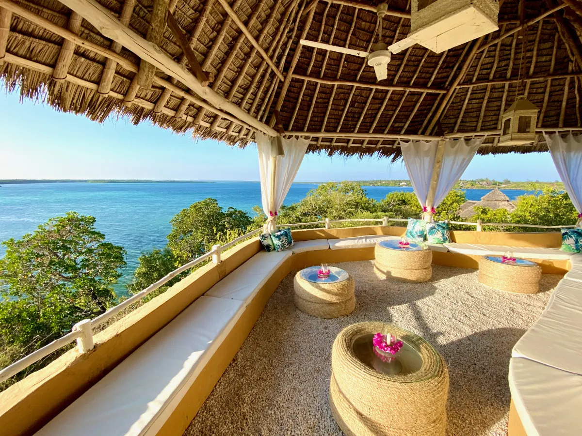 The thatched panoramic lounge with curtained arches and cushioned seating, looking out over the Indian Ocean