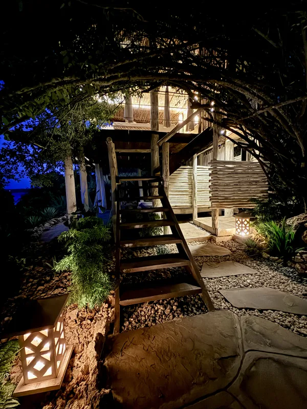The lit garden archway leading up to Jua Spa after dark
