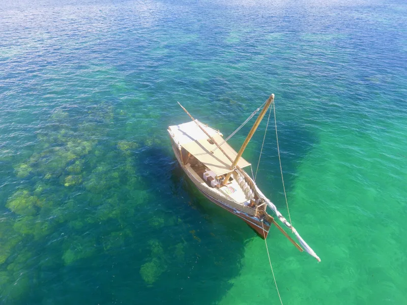 The Pepo Huru at anchor over the turquoise shallows of Watamu Marine Park, seen from above