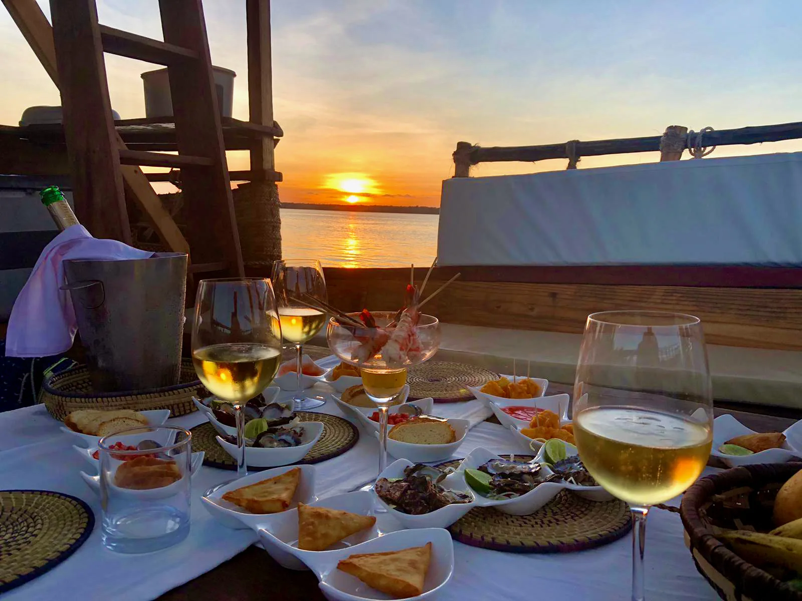 Chilled glasses and gourmet bites laid out on board as the sun goes down